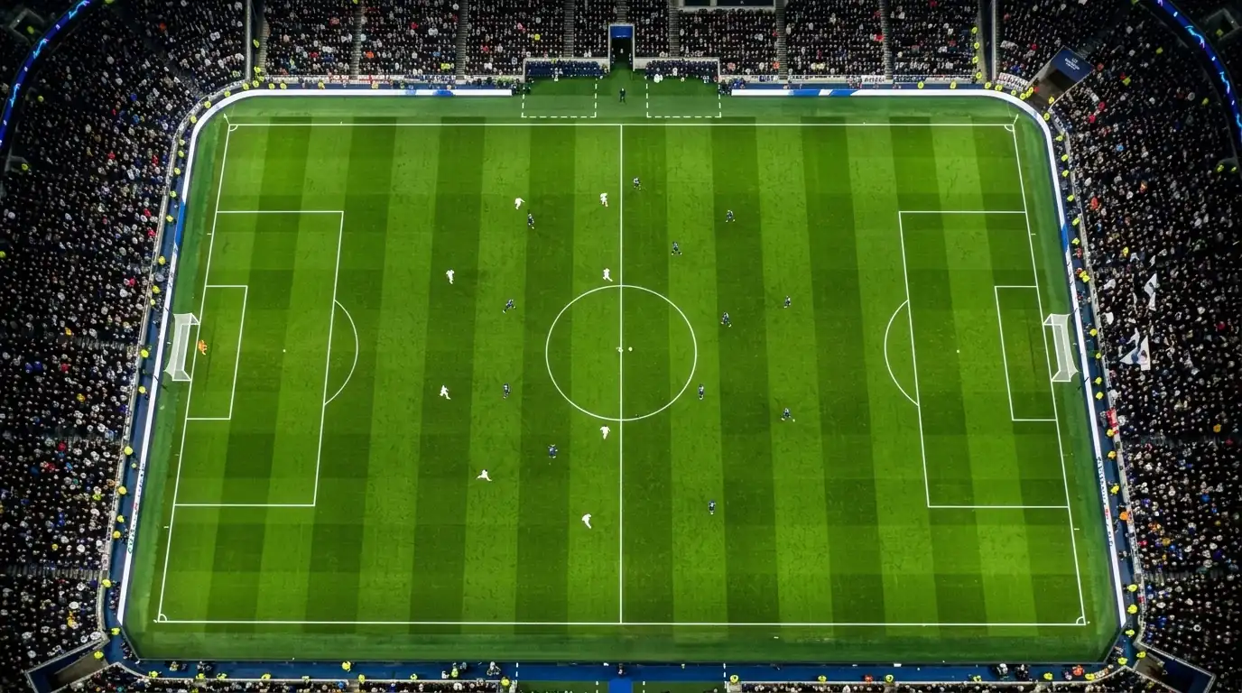 Vista cenital de un campo de fútbol profesional con marcas tácticas y líneas de juego durante un partido nocturno